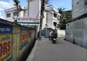 a man riding a motorcycle down a street at Hotel Green City, Khulna in Khulna