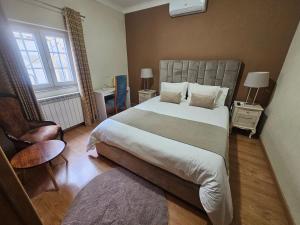 a bedroom with a large bed and a chair at Alfatima in Manteigas +105 photos