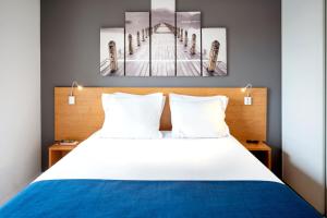 - une chambre avec un lit orné de deux peintures murales dans l'établissement Séjours & Affaires Annecy Le Pont Neuf, à Annecy