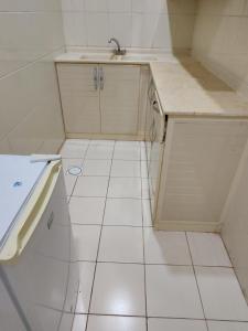 a small kitchen with a sink and a tiled floor at جناح فاخر غرفتين نوم وصالة تلفزيون in Rayyis