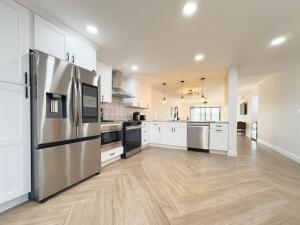 a large kitchen with white cabinets and stainless steel appliances at Golfer's Dream! Beautiful Condo At Kelly Greens in Fort Myers