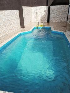 a large swimming pool with blue water at Maison charmante à Petit-Bourg + Jardin in Petit-Bourg