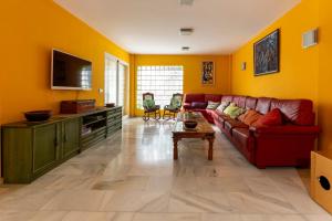 a living room with a red couch and yellow walls at Villa Super Lujo Mojacar -7 hab - piscina - vistas al mar in Mojácar