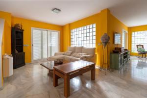 a living room with yellow walls and a couch and a table at Villa Super Lujo Mojacar -7 hab - piscina - vistas al mar in Mojácar