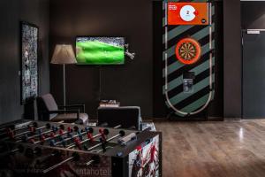 una camera con una tavola da freccette gigante e una TV di pentahotel Eisenach a Eisenach