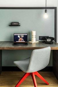 a desk with a laptop and a chair at Pentahotel Rostock in Rostock +77 photos