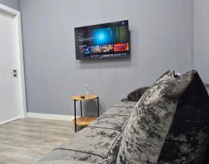 sala de estar con sofá y TV de pantalla plana en la pared en Тихий Замок, en Bishkek