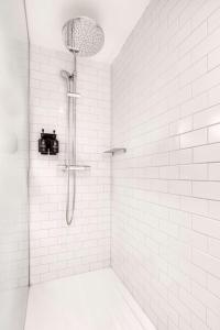 a bathroom with a shower with white tiles at pentahotel Brussels City Centre in Brussels