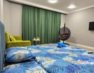 1 dormitorio con cama azul y cortina verde en Тихий Замок, en Bishkek 18 fotos más