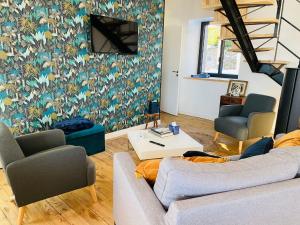 a living room with a couch and two chairs at La GRANGE BY CARO in Cantoin