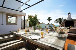 a wooden table on the patio of a house at Beachfront townhouse with spectacular seaview in Estepona