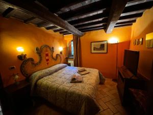 a bedroom with a bed in a room with orange walls at Il borgo di Firenzuola Camere con camino in Acquasparta