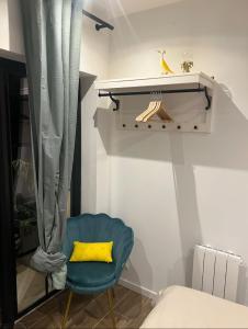 a bedroom with a blue chair with a yellow pillow at Chambre indépendante proche du Circuit des 24h et du Pôle Européen du Cheval in Yvré-lʼÉvêque