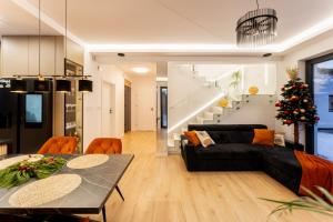 Una sala de estar con un sofá negro y una mesa. en ZinHouse Wojakowa, en Wojakowa