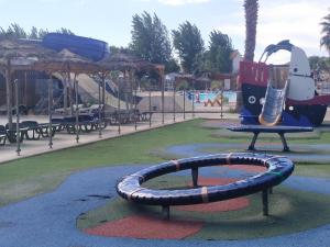 un patio de recreo con un tobogán en un parque en MOBIL HOME l'ETOURNEAU, en Valras-Plage