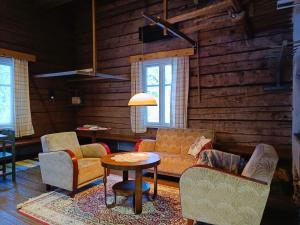 a living room with a couch and chairs and a table at Jussila in Syöte