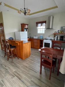 a kitchen with a table and chairs and a kitchen with a stove at Hidden Treasure Vacation Home Bay Blue Suite 2 in Belize City