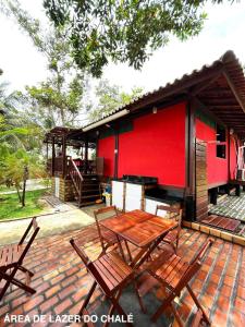 a patio with a table and chairs in front of a building at Refúgio em Barreirinhas Chalé in Barreirinhas