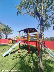 a playground with a slide and a tree at Refúgio em Barreirinhas Chalé in Barreirinhas