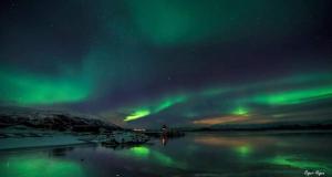 an aurora in the sky over a body of water at Koselig rom i sentrum Gratis Wifi og Parkering Rom 1 in Narvik