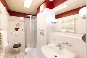 a bathroom with a sink and a shower and a toilet at OST29 Ferienwohnung Komoran in Niendorf +9 photos