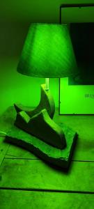 une chambre verte avec un lit et une lampe dans l'établissement Bilocale relax in Cesana, à Césane 2 autres photos