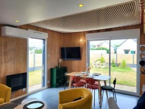 サン・ジェルマン・シュル・エにあるVilla Malgira, bord de merのテーブルと椅子とテレビのあるリビングルーム