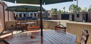 a wooden table with an umbrella on a patio at 401 Restaurant & Accommodation in Naivasha
