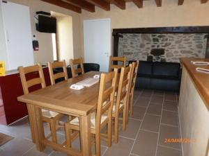a dining room with a table and chairs and a fireplace at Maison du meunier in Soursac