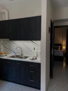 a kitchen with a sink and a room with a bed at HERA QUEEN Boutique in Larisa +22 photos