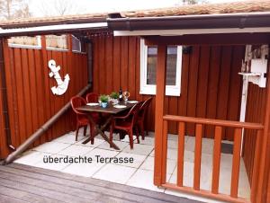 a patio with a table and chairs on a deck at Möwe 30 in Mirow