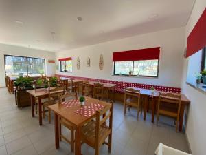 a restaurant with wooden tables and chairs in a room at Parque de Campismo Orbitur Valado in Nazaré