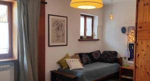 un salon avec un canapé et une fenêtre dans l'établissement Bilocale relax in Cesana, à Césane