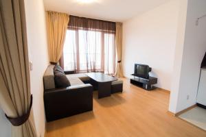 a living room with a couch and a tv at Cabacum Beach Private Apartaments in Golden Sands