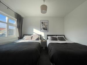 two beds sitting next to each other in a bedroom at Spacious and Modern Home in Woodhouse - Sleeps 10 in Central Station