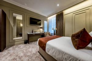 a hotel room with a bed and a desk at Walled City Hotel in Derry Londonderry