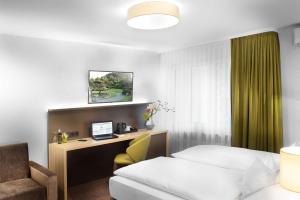 a hotel room with a bed and a desk with a computer at Best Western Hotel Favorit in Ludwigsburg +56 photos
