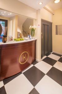 a hotel lobby with a reception desk and a checkered floor at Best Western Plus Grand Hotel Victor Hugo in Luxembourg