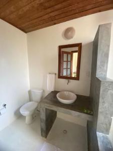a bathroom with a sink and a toilet at Pousada Jardim Cambuí Beach in Itacimirim +39 photos
