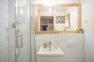 a bathroom with a sink and a glass shower at Domek gościnny 'Rumcajsówka' in Ząb