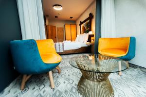 a room with two chairs and a table and a bed at Pensiunea La Vâltoare in Sibiu +97 photos