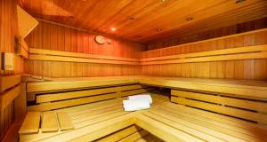 a large wooden sauna with a white towel in it at PLAZA INN Heidehof in Hermannsburg