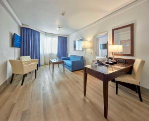a hotel room with a desk and a blue couch at Best Western Hotel Trier City in Trier
