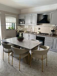 eine Küche mit Tisch und Stühlen und einer Spüle in der Unterkunft Villaricardo_azeitao Moradia moderna para 9 guests in Azeitão