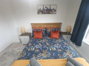 a bedroom with a bed with blue and orange pillows at Steam Train Cottage in Aviemore
