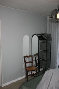 a bedroom with a chair and a book shelf at Gîte étape des Brimbelles in Anould
