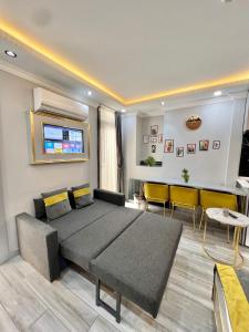 a living room with a large bed and yellow chairs at TAKSİM LARİSSA RESİDENCE in Istanbul