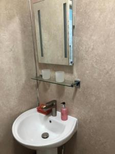 a bathroom sink with a mirror and a red soap at Ravensworth House in Keswick