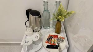 a table with a vase of flowers and bottles on it at Sea Sun Stay in Maafushi