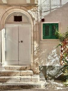 a building with a door and a green window at Terrazza De Palma, Vista e Relax in Monopoli